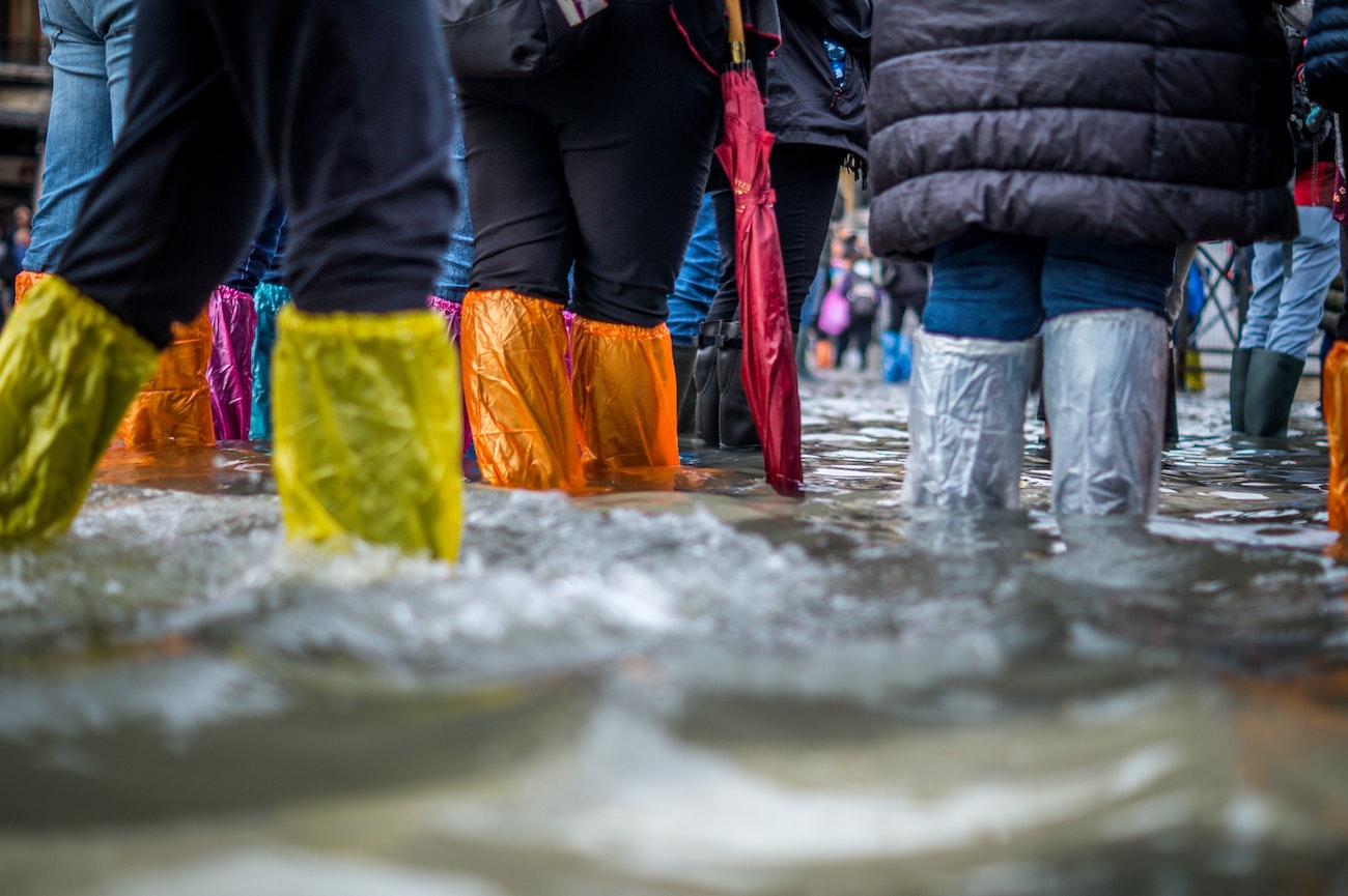 Personas de pie en un zona inondada