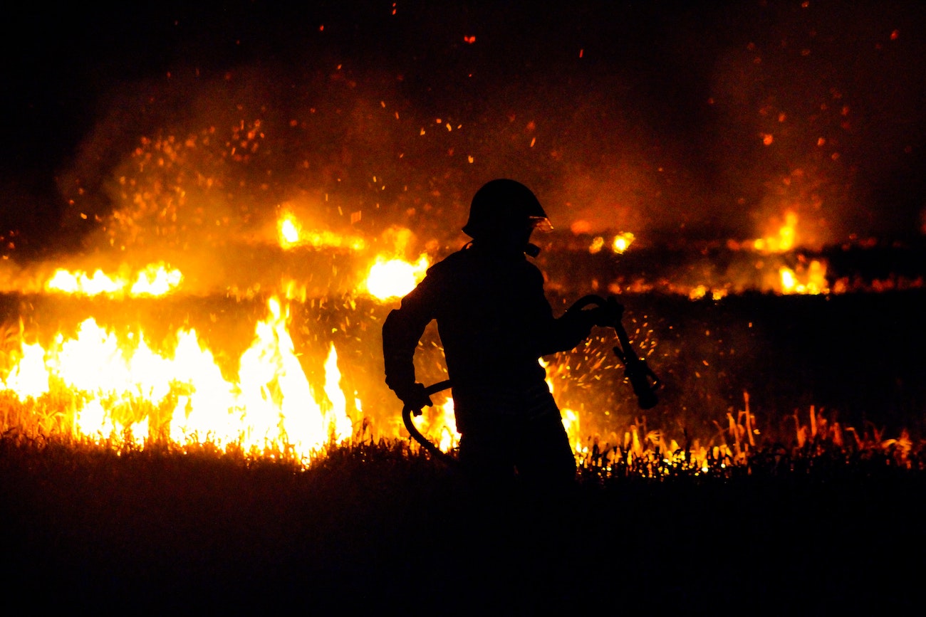 Un bombero lucha contra las llamas durante la noche